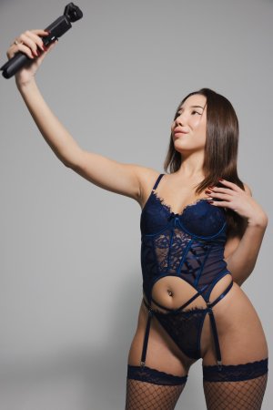 Layla Scarlett poses in blue lace lingerie and fishnet stockings holding a camera in studio — Layla Scarlett #1
