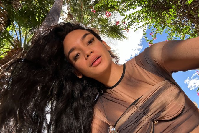 Dulce poses solo outdoors in sheer top under palm trees tongue out with sunlight on her skin — Dulce #4