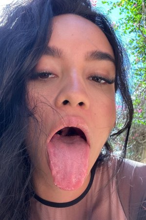 Dulce poses solo outdoors in sheer top under palm trees tongue out with sunlight on her skin — Dulce #5