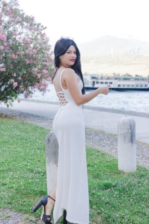 Lilith Baph crouches barefoot on concrete, tongue out, white dress riding high over her tattooed thighs — Lilith Baph #3