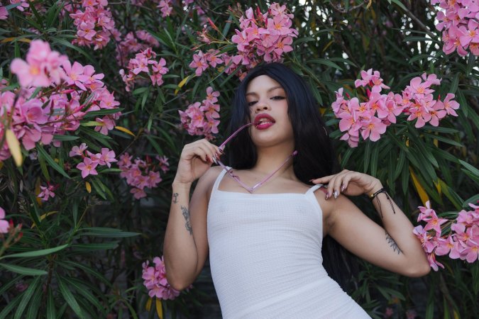 Lilith Baph crouches barefoot on concrete, tongue out, white dress riding high over her tattooed thighs — Lilith Baph #4