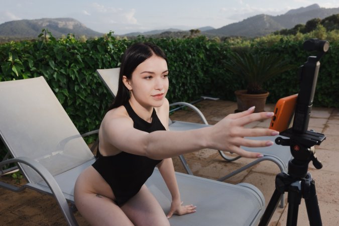 Wikki Kee solo by the pool in black bodysuit, teasing with a butt plug under sunny skies — Wikki Kee #4
