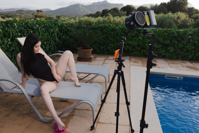 Wikki Kee solo by the pool in black bodysuit, teasing with a butt plug under sunny skies — Wikki Kee #7