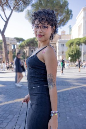 Lilith Baph poses solo in Rome with the Colosseum behind her, black dress and hoop earrings on display — Lilith Baph #5