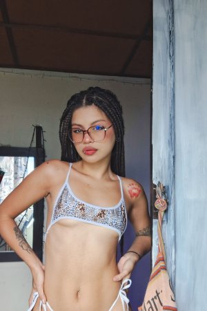 Lilith Baph in white bikini poses with leg up showcasing her tattooed curves and braids indoors — Lilith Baph #4