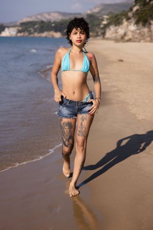 Lilith Baph teases in denim shorts and bikini, sunlit beach posing with tattoos on display — Lilith Baph #3