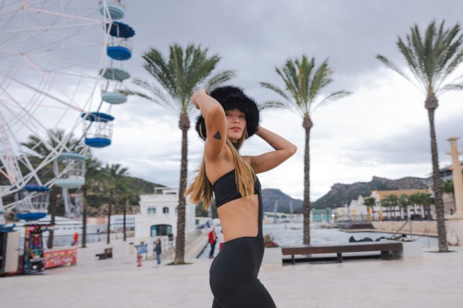 Irene Rouse teases in black bodysuit and fur hat by the Ferris wheel, her curves on full display for the camera — Irene Rouse #6
