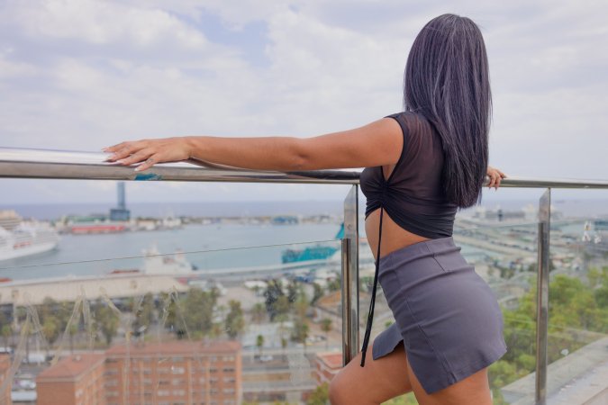 Why Effy teases on the balcony in sheer top and grey skirt with city views behind her — Why Effy #2