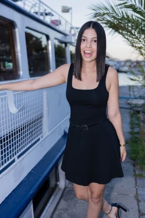Gia Rosse leans against stone wall in black dress outdoors posing with gold necklace and wristwatch — Gia Rosse #4