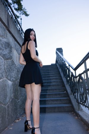 Gia Rosse leans against stone wall in black dress outdoors posing with gold necklace and wristwatch — Gia Rosse #9