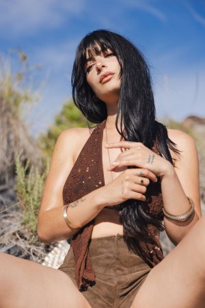 Sary Catalina squatting outdoors in brown shorts, wind blowing her hair as she teases her body — Sary Catalina #5