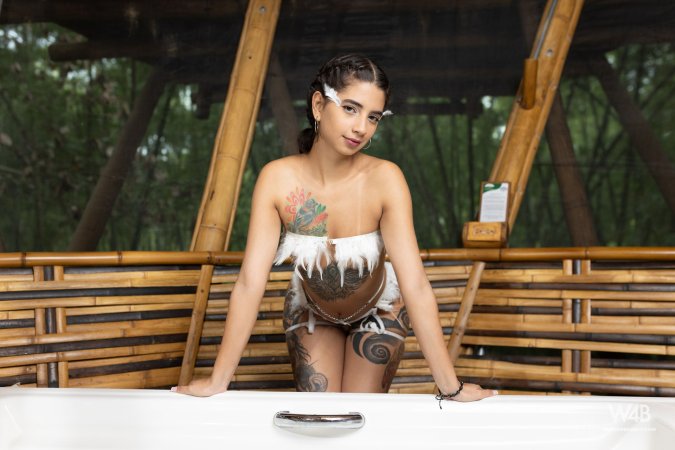 Tormenta in white feathered lingerie poses solo in a bamboo tub, teasing with her tattooed curves and slow self touch — Tormenta #5