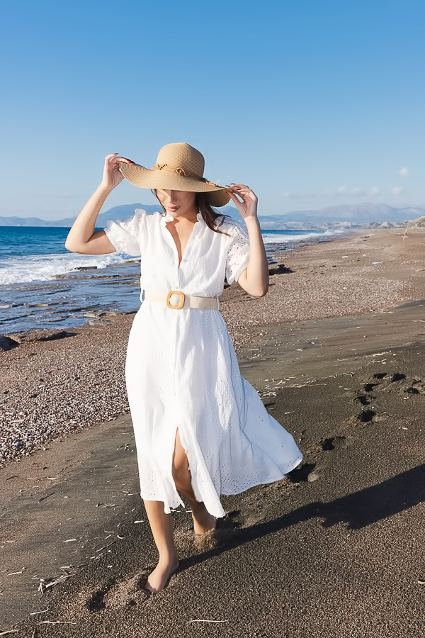 Layla Scarlett teases in a white dress on a windy beach, fingers brushing her curves under the sun
