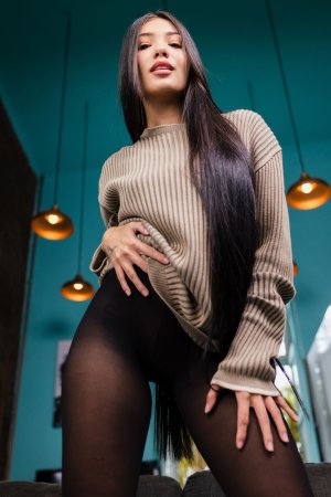 Yeye Guzman sits solo on gray couch in ribbed sweater and black stockings teasing camera — Yeye Guzman #3