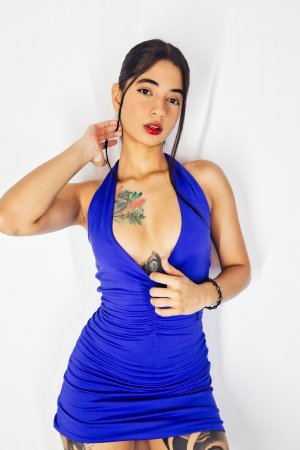 Tormenta in blue halter dress posing solo, red lips and tattoos on display against white backdrop — Tormenta #2