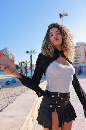 Valery Ponce stands poised on the Spanish coast, blonde curls framing her face as she poses in black boots and lace, sunlight tracing every curve — Valery Ponce #1