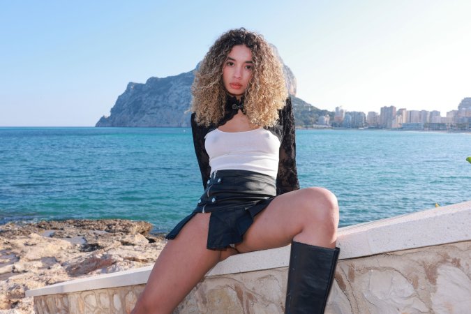 Valery Ponce stands poised on the Spanish coast, blonde curls framing her face as she poses in black boots and lace, sunlight tracing every curve — Valery Ponce #7
