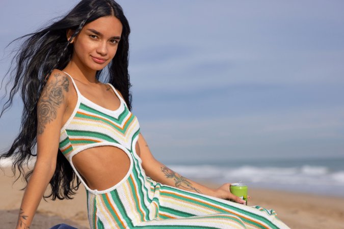 Dulce, beach breeze teasing her striped jumpsuit, whispers secrets only her tattoos know — Dulce #2