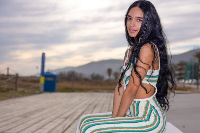 Dulce, beach breeze teasing her striped jumpsuit, whispers secrets only her tattoos know — Dulce #6