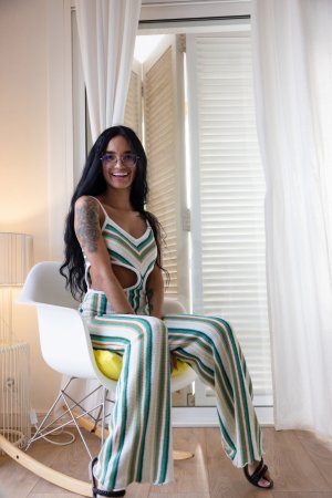 Dulce, beach breeze teasing her striped jumpsuit, whispers secrets only her tattoos know — Dulce #9