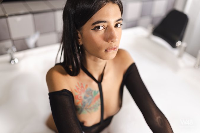 Tormenta teases in black fishnet lingerie, city lights behind her, tattoos gleaming on skin — Tormenta #4