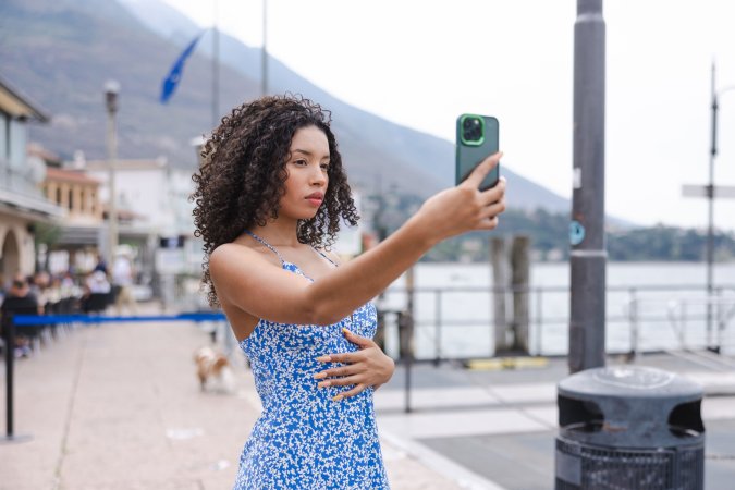 Valery Ponce bends over a gate by Lago Di Garda, flashing her bare ass in a tiny blue dress, teasing passersby — Valery Ponce #14