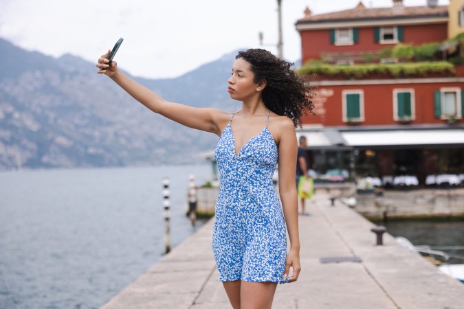 Valery Ponce bends over a gate by Lago Di Garda, flashing her bare ass in a tiny blue dress, teasing passersby — Valery Ponce #16