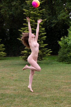 Guinevere Huney teases in orange bikini outdoors tossing rainbow ball with playful smile — Guinevere Huney #23
