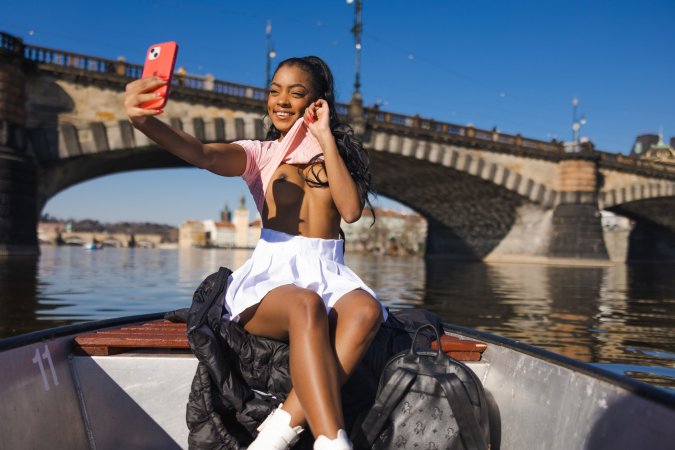 Sofi Vega licks ice cream by the river in pink top and white skirt, smiling for the camera — Sofi Vega #8