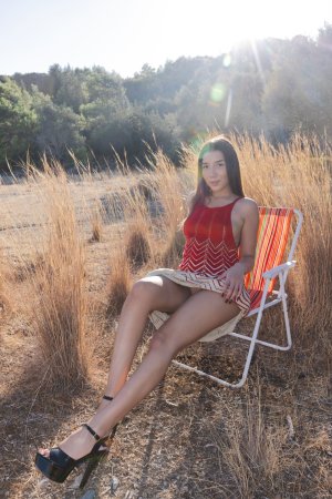 Layla Scarlett in red backless dress poses solo on rural road under sun with straw hat and heels — Layla Scarlett #22