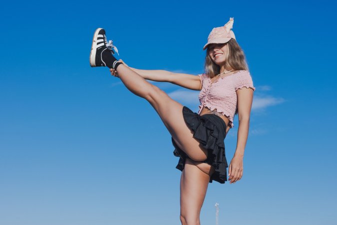Irene Rouse spreads wide on stone wall under blue sky, solo pose showing off her gymnast flexibility — Irene Rouse #15