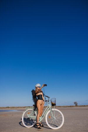 Irene Rouse teases in black lingerie and wings on a beach bike under blue sky posing solo — Irene Rouse #23