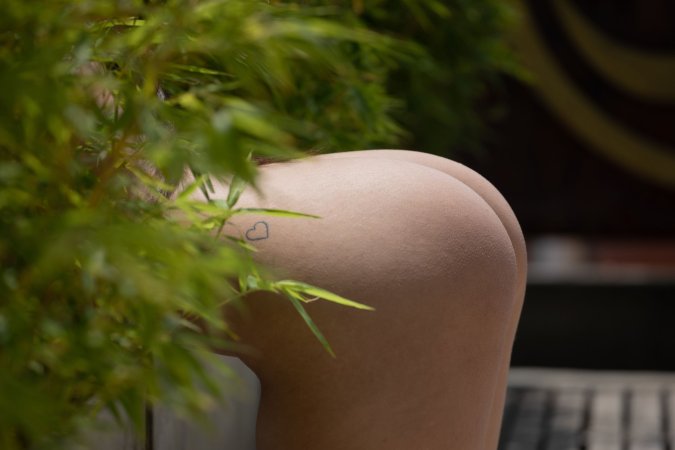 Mia Carson bares her soft skin outdoors, green eyes gleaming as she smiles with black lace against her tattooed collarbone — Mia Carson #16