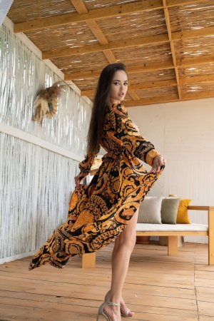 Li Moon teases in a backless patterned dress on a wooden deck lifting her leg high in heels — Li Moon #2