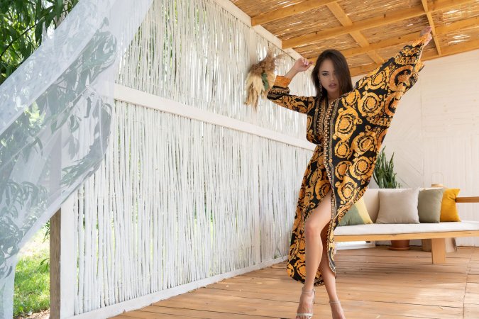 Li Moon teases in a backless patterned dress on a wooden deck lifting her leg high in heels — Li Moon #3