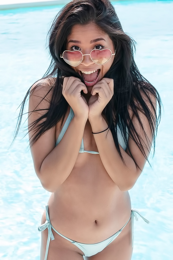 Karin Torres smiles in her bikini by the pool, playful and confident, showing off her toned body