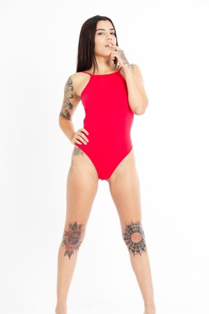 Sofi Reyes poses in red bodysuit against white backdrop showcasing her tattoos and curves — Sofi Reyes #1
