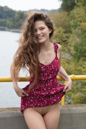 Irene Rouse in red floral dress poses solo against stone wall under Prague sun heat — Irene Rouse #3