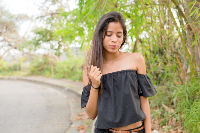 Karin Torres poses solo on a leafy path, black off shoulder top riding up over her hips, long hair swaying with each turn — Karin Torres #3