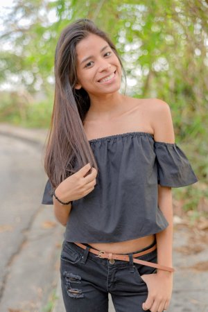 Karin Torres poses solo on a leafy path, black off shoulder top riding up over her hips, long hair swaying with each turn — Karin Torres #5