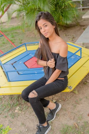 Karin Torres poses solo on a leafy path, black off shoulder top riding up over her hips, long hair swaying with each turn — Karin Torres #6