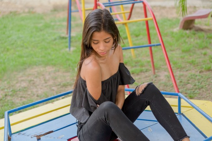 Karin Torres poses solo on a leafy path, black off shoulder top riding up over her hips, long hair swaying with each turn — Karin Torres #14
