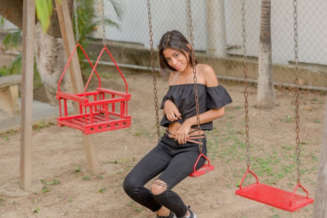 Karin Torres poses solo on a leafy path, black off shoulder top riding up over her hips, long hair swaying with each turn — Karin Torres #19