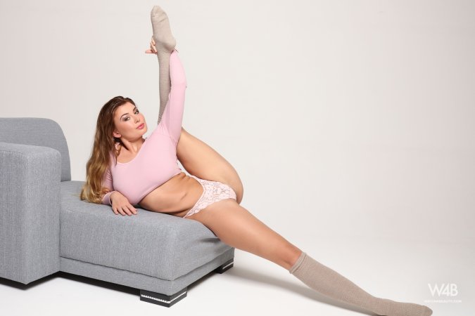 Lucy spreads her legs on the gray couch in lace underwear and knee high socks, teasing with her pink top — Lucy #1