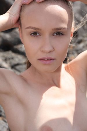 Angel B posing solo in black swimsuit on rocky terrain under blue sky, sneakers on feet — Angel B #12