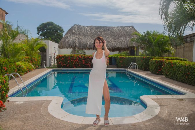 Natali Leon teases by the pool in a white swimsuit, barefoot and smiling as she lifts the fabric to reveal more — Natali Leon #1