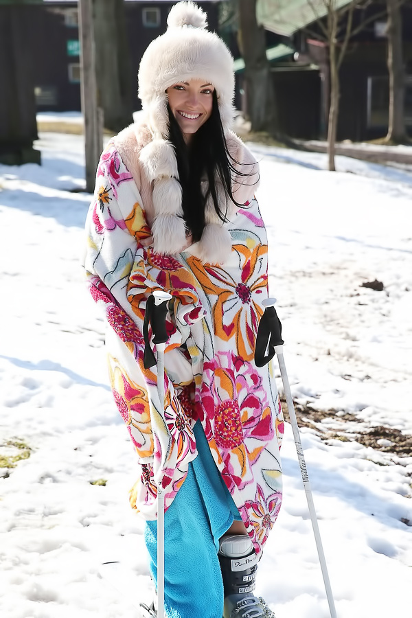 Sapphira applying makeup in car wearing tiger print sweater smiling with natural light and pink bag nearby