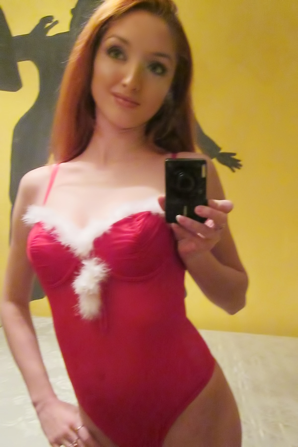 W4b kneels on bed in red lingerie taking mirror selfies topless with red stockings in bedroom