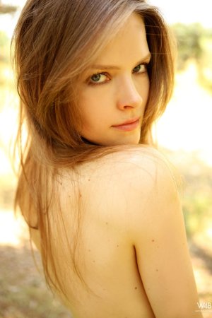 Lilian White stands bare in white lace outdoors, sunlight catching her curves as she poses slow — Lilian White #8